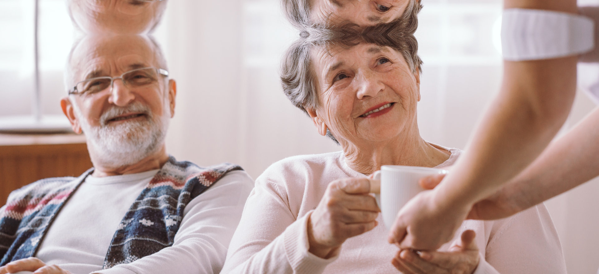 caregiver and an elderly with a mug