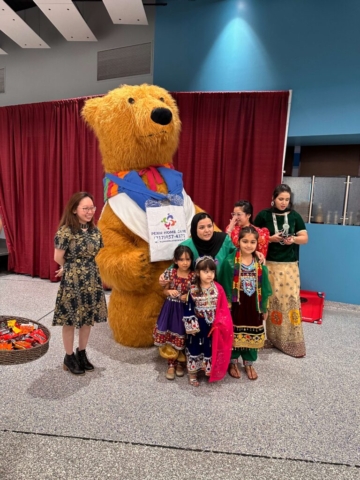 kids and a bear mascot behind them