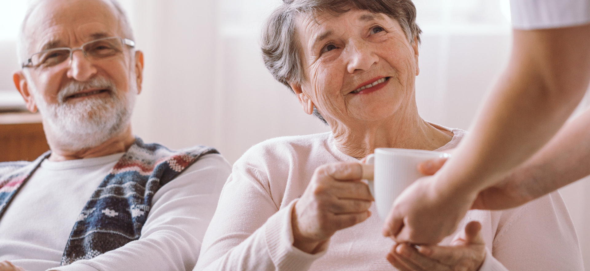 caregiver and an elderly with a mug